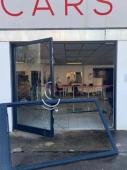 Smashed entrance doors in Wigan before repair